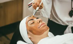 Kobieta z maską na twarzy, przygotowująca się do zabiegu hydrodermabrazji.
