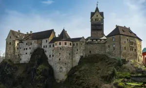 Zamek na skale, wspaniałe roztocze atrakcje. Kamienne mury, wieże i dachy pod błękitnym niebem.