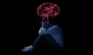 Ciemna postać skulona, z mózgiem rozświetlonym czerwonymi błyskawicami. To wizualizacja, jak dystymia objawy mogą wpływać na umysł.