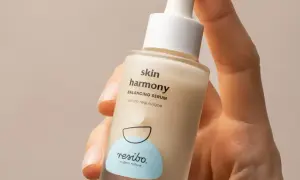 Dłoń trzyma buteleczkę serum Resibo Skin Harmony. Składnik alantoina wspiera regenerację skóry.