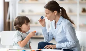 Terapeuta enseña trabalenguas para niños usando piezas de letras.