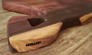 Tabla de cortar artesanal con veta de madera africana, marcada con "SKULLART".
