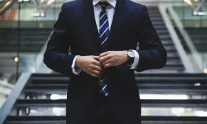 Mann im dunkelblauen Sakko mit gestreifter Krawatte, perfekt für eine Hochzeit.