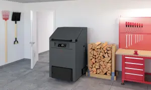 Holzstapel neben einem modernen Heizkessel, der bald dem Festbrennstoffkessel Verbot zum Opfer fallen könnte. Werkzeuge hängen an der Wand.
