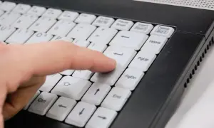 Palec naciska klawisz Enter na klawiaturze ultrabooka. Co to jest ultrabook? To lekki i cienki laptop.