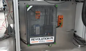 Wewnątrz przezroczystej obudowy widać system sterowania z napisem "REVOLUTION PI POWERED BY Raspberry Pi". To pokazuje, że raspberry co to za urządzenie, które zasila ten przemysłowy komputer.