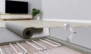 Instalacja ogrzewania podłogowego, gdzie rurki grzewcze są układane na siatce, a następnie przykrywane warstwą izolacji i przygotowywane pod wylewkę.