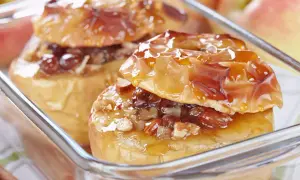 Deux pommes au four dorées, garnies de noix et de raisins secs, nappées d'un sirop brillant. Un délice réconfortant.