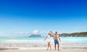 Ett lyckligt par dansar på stranden i San Juan, med ett kryssningsfartyg i bakgrunden.