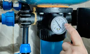 Palec wskazuje manometr hydroforu, pokazując ciśnienie. Proces jak odpowietrzyć hydrofor jest kluczowy dla jego prawidłowego działania.