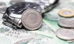 Zegarek i monety na banknotach. Czy to symbol najniższa krajowa na godzinę?