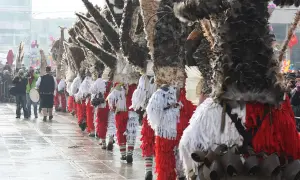 Un corteo di kukeri bulgari in costumi elaborati con piume e campanelli, pronti a scacciare il male.