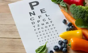 Tablica optometryczna z warzywami i owocami: marchew, brokuły, papryka, borówki, szpinak.