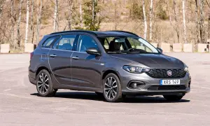 En mörkgrå Fiat Tipo kombi står parkerad utomhus. Bilen har en man bakom ratten.
