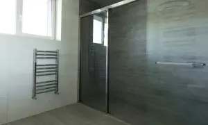 Modernes Bad mit Dusche und Handtuchwärmer. Die **bad elektroheizung** sorgt für wohlige Wärme.