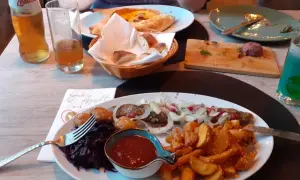 Ein köstliches Gericht mit Fleischspieß, Kartoffelspalten und Rotkohl in einem georgischen Restaurant in Halle.