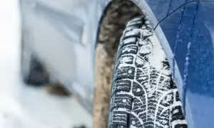 Zimowe opony w Austrii, gotowe na śnieżne drogi. Bieżnik pokryty białym puchem, zapewniający przyczepność.