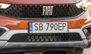 Pomarańczowy Fiat z tablicą rejestracyjną SB 790EP. Detale przedniego grilla i logo marki.