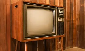 Stary telewizor z drewnianą obudową i ekranem kineskopowym. Ciekawe, w którym roku powstał pierwszy telewizor, bo ten wygląda na prawdziwy antyk.