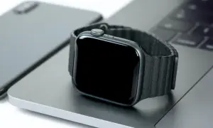 Smartwatch nie działa wyświetlacz. Czarny ekran zegarka na tle laptopa i telefonu.