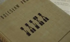 Okładka książki Bolesława Prusa "Lalka", która ukazuje motyw cierpienia w literaturze.