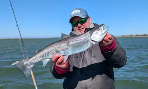 Glücklicher Angler hält stolz einen großen Fisch, den er beim Limburg Angeln gefangen hat.