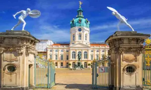 Pałac Charlottenburg w Berlinie, z jego kopułą i bogatymi zdobieniami, zachwyca w stylu na końcu baroku. Dwie białe rzeźby wojowników strzegą wejścia.