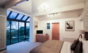Habitación moderna con grandes ventanales que dan a un jardín. Ideas para como hacer un balcón en una casa ya construida.