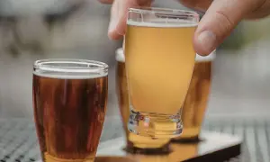 Assaggio di una fresca italian pale ale dorata, con un'altra birra ambrata in primo piano.