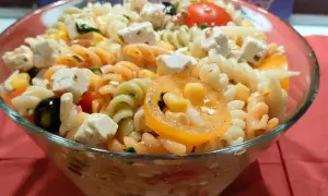 Kolorowa sałatka z makaronem fusilli, serem feta, oliwkami, kukurydzą i pomidorkami. Idealna na letnie dni.