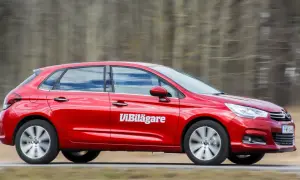 Röd Citroen C4 i fart, med texten "Vi Bilägare" på sidan. Bilen är på en väg med träd i bakgrunden.