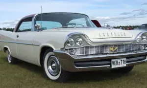 Vit Chrysler 58 med rött tak, blanka kromdetaljer och vit sidovägg på däcken. Bilen står på en gräsmatta.