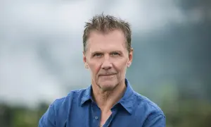 Johan Gullberg, en man med väderbitet ansikte och rufsig frisyr, bär en blå skjorta. En bild som väcker tankar, nästan som en flashback.