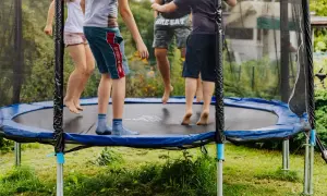 Dzieci skaczą na trampolinie, świetna zabawa i aktywność fizyczna. Czy trampolina jest zdrowa dla dzieci? Tak, rozwija koordynację i kondycję.