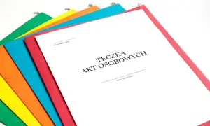 Kolorowe teczki z dokumentami, jedna z nich to Teczka Akt Osobowych część A, gotowa do wypełnienia.
