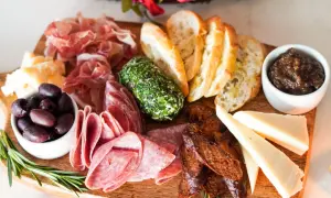 Planche apéro gourmande : charcuteries fines, fromages variés, olives, pain grillé, confiture de figues et fromage frais aux herbes. Une belle idée pour un moment convivial.