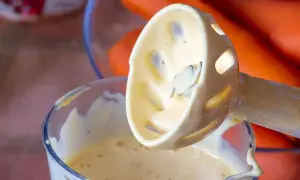 Batidora de inmersión con mayonesa casera cremosa, lista para acompañar unas zanahorias frescas.