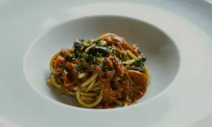 En portion spaghetti med en smakrik tomatsås, oliver och kapris. Perfekt vin till pasta puttanesca.