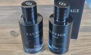 Dwa flakony Dior Sauvage Parfum 100ml, każdy z czarną zakrętką z logo CD.