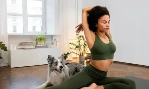 Frau dehnt sich mit ihrem Hund, um gelenkiger zu werden.