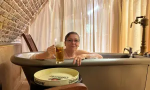Entspannte Frau mit Bier im Bad des Chodovar Hotels.