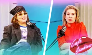 Eva Ekselius med bandana och solglasögon sitter vid en mikrofon. Bredvid henne sitter en kvinna i orange klänning.