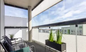 Nowoczesne, przesuwne szyby i białe plisy to idealne rozwiązanie, czym osłonić balkon, zapewniając prywatność i ochronę przed słońcem.