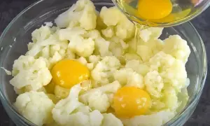 Do miski z kalafiorem dodawane są jajka. Powstaje pyszny kalafior z jajkiem.