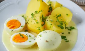 Saure Eier Rezept: Gekochte Eier und Kartoffeln in cremiger Sauce, garniert mit Petersilie. Ein einfaches und leckeres Gericht.