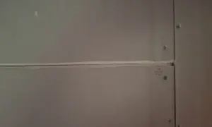 Närbild på gipsskivor där skarvarna spacklas för att skapa en jämn yta. Skruvarna syns tydligt.
