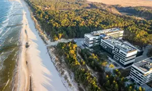 Traumhafter **Polen Urlaub** an der Ostsee: Moderne Hotels neben einem breiten Sandstrand und Kiefernwald.