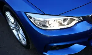 Gros plan sur le phare d'une voiture bleue éclatante, prêt à illuminer la route.