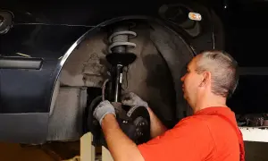 Mechanik naprawia zawieszenie, by auto nie ściągało w lewo podczas jazdy.