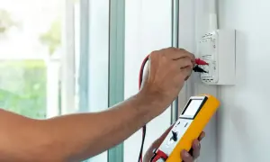 Elektryk mierzy impedancję pętli zwarcia za pomocą miernika.
